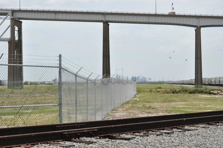 Long industrial security fence near rail corridor